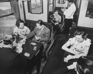 Passengers playing cards in a third class carriage  February 1938.