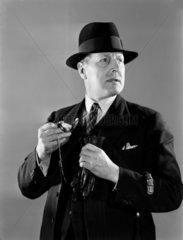 Man holding a watch  c 1950.