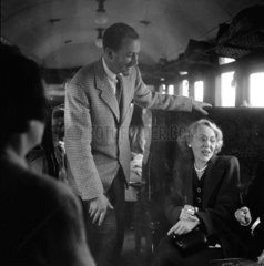 Colin Wills talking with a woman during a train journey  1950.