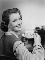 Woman drinking a cup of tea  1951.