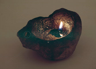 Primitive lamp  a stone used as a floating wick holder  1801-1900.