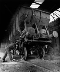 Two men in repair shop fit wheels on to rail wagons  Swansea  1961.