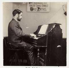 Man playing the organ  c 1905.