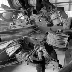 A worker setts up at bobbins at laying up machine  Pirelli General Cable  1965.