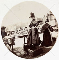 Woman at a market stall  c 1890.
