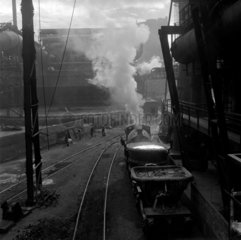 A steam engine pulls a waggon of slag from ladle  Consett Iron Company  1957.
