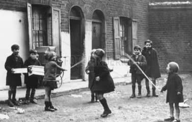 Children playing with a skipping rope in the street  19 October 1946.
