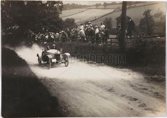 Motor car driving uphill on a country road  c 1912