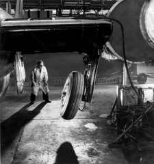 A technician inspects a wheel fitted to undercarriage of Canberra 8 aircraft.