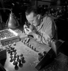 A worker sets lenses for polishing  Kershaw and Sons   Leeds  1953.