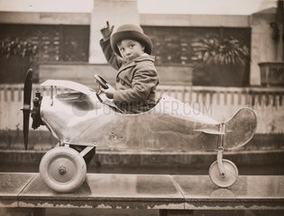 Boy sitting in a toy aeroplane  Selfridges  London  18 December  1931.