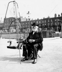 Old man with weighing chair  1900s.