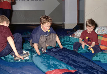Children getting into sleeping bags during