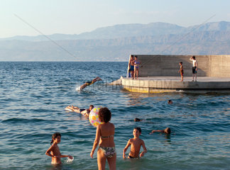 Postira  Kroatien  Insel Brac  Urlauber baden am Stadtstrand