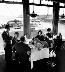 Manchester Airport  family in restaurant with BEA Vanguard behind  1965.