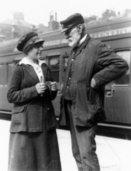 Female ticket inspector and an elderly rail