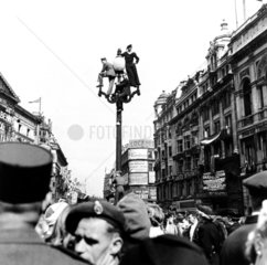 Servicemen watching VE Day crowds from the