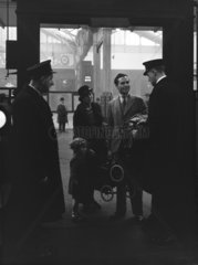 A family having their tickets checked at a station platform barrier  1936.
