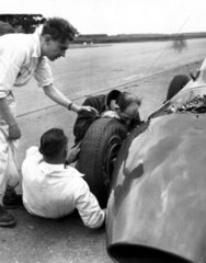 Stirling Moss fixing a wheel  June 1959.
