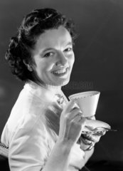 Woman holding a teacup and saucer  1948.