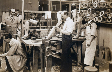 Making wooden prosthetic limbs during World War One  c 1915-1918.
