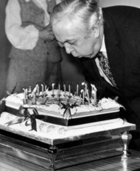 Harold Wilson blowing out candles on a cake  February 1975.