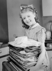 Girl carrying a pile of laundry  1950.