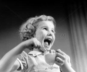 Laughing girl eating dessert  1950.