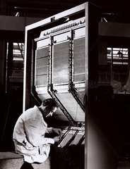 An engineer assembles IBM box computer at English Electric  1958.