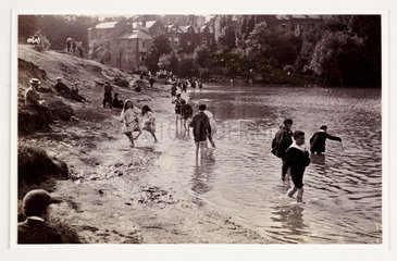 Children playing in a river  c 1900