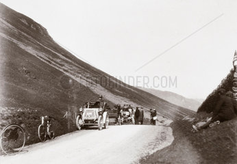 Motor cars parked along a road in the hills during 1000 Mile Trial  1900.