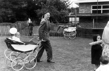 Man pulling a baby in a pram  Holland Park  London  1967.