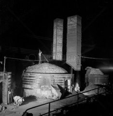 A quarryman stands on kiln to sample tiles at night  Stoke on Trent   1955.