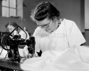 Repairing laundry  1952. A woman operating
