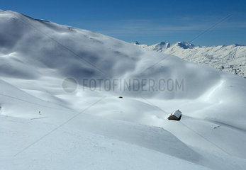 Valbella  Schweiz  Berghuette in einem schneebedeckten Tal