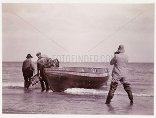 Two fishermen being photographed  c 1930.