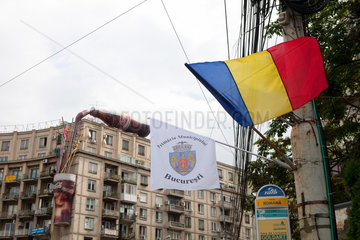 Bukarest  Rumaenien  die Rumaenischen Fahne  die Bukarestfahne und eine Coca Cola Fassadenwerbung im Hintergrund