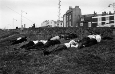 Young and middle-aged men lying on grassy hill near B2052 trunk road  1967.