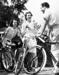Three cyclists with tennis racquets  1940s.