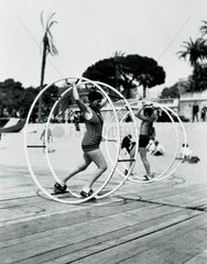 Couple using exercise wheels on a Florida beach  United States  c 1935.