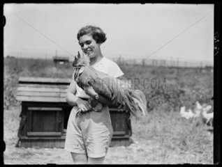 Young woman with cockerel  Hertfordshire  15 June 1937.