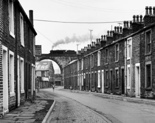 Steam train crossing a viaduct over a terraced street  Lancashire  7 July 1968.