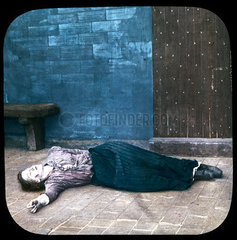 Woman lying unconscious on the floor of a prison cell  c 1895.