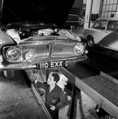 Garage mechanic in pit greasing Ford Zephyr 6 car