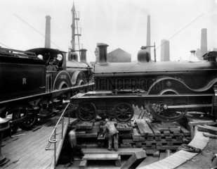 Steam locomotive being jacked up to track level after an accident  c 1895.