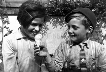 Young boy offering his ice cream to a girl.