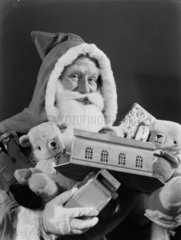 Father Christmas carrying toys  1950.