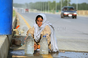 Nowshera  Pakistan  eine Frau holt am Strassenrand Wasser
