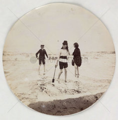 Two girls and a boy paddling in the sea  c 1890s.