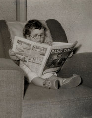 Small boy reading the ‘Radio Times’  1950s.